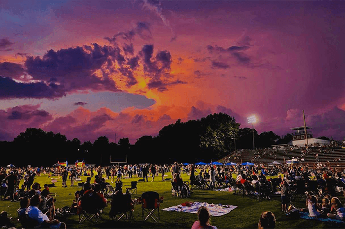 Sunset with large field of people